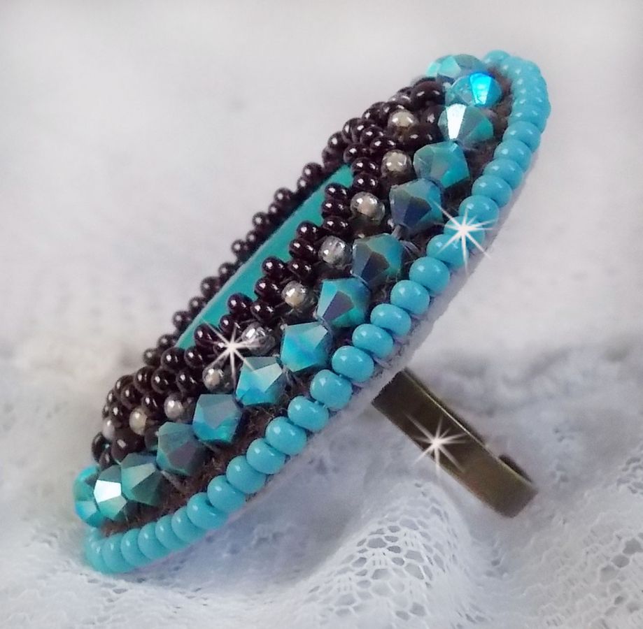 Bague Turquoise au style Am&eacute;rindien avec un cabochon ovale en pierre de gemme : le Turquoise lui-m&ecirc;me orn&eacute; de toupies en Cristal, s&rsquo;ajoute des rocailles en verre Miyuki et tch&egrave;que sur une bague Bronze