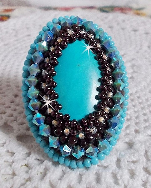 Bague Turquoise au style Am&eacute;rindien avec un cabochon ovale en pierre de gemme : le Turquoise lui-m&ecirc;me orn&eacute; de toupies en Cristal, s&rsquo;ajoute des rocailles en verre Miyuki et tch&egrave;que sur une bague Bronze