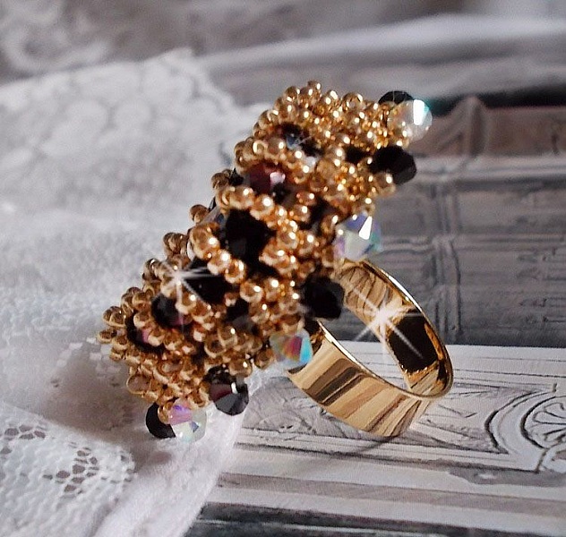 Bague Noir Sacr&eacute; brod&eacute;e avec des cristaux : navette et toupies, perles rondes nacr&eacute;es Blanches &agrave; laquelle s&rsquo;ajoute des facettes en verre de boh&egrave;me Jet Capri Gold et rocailles sur une bague r&eacute;glable