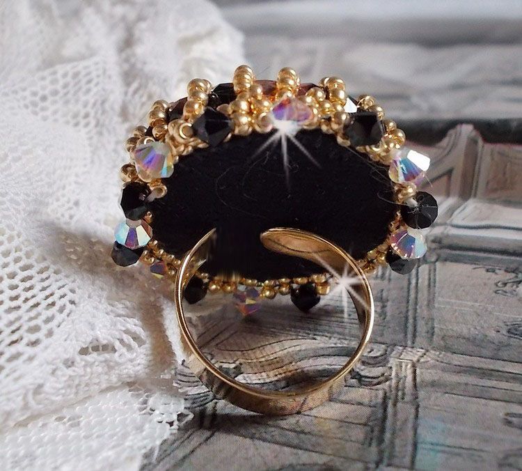 Bague Noir Sacr&eacute; brod&eacute;e avec des cristaux : navette et toupies, perles rondes nacr&eacute;es Blanches &agrave; laquelle s&rsquo;ajoute des facettes en verre de boh&egrave;me Jet Capri Gold et rocailles sur une bague r&eacute;glable