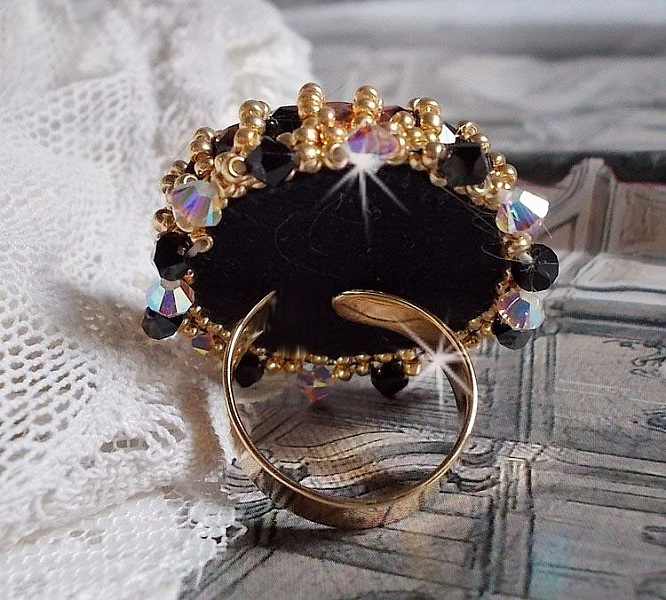 Bague Noir Sacr&eacute; brod&eacute;e avec des cristaux : navette et toupies, perles rondes nacr&eacute;es Blanches &agrave; laquelle s&rsquo;ajoute des facettes en verre de boh&egrave;me Jet Capri Gold et rocailles sur une bague r&eacute;glable