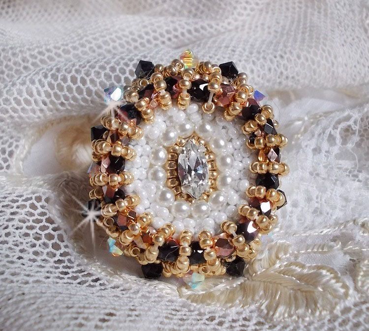 Bague Noir Sacr&eacute; brod&eacute;e avec des cristaux : navette et toupies, perles rondes nacr&eacute;es Blanches &agrave; laquelle s&rsquo;ajoute des facettes en verre de boh&egrave;me Jet Capri Gold et rocailles sur une bague r&eacute;glable