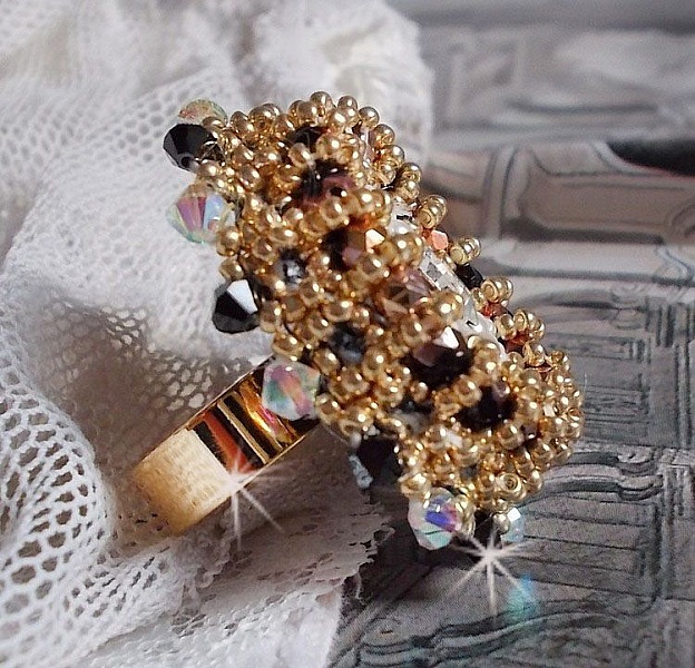 Bague Noir Sacr&eacute; brod&eacute;e avec des cristaux : navette et toupies, perles rondes nacr&eacute;es Blanches &agrave; laquelle s&rsquo;ajoute des facettes en verre de boh&egrave;me Jet Capri Gold et rocailles sur une bague r&eacute;glable