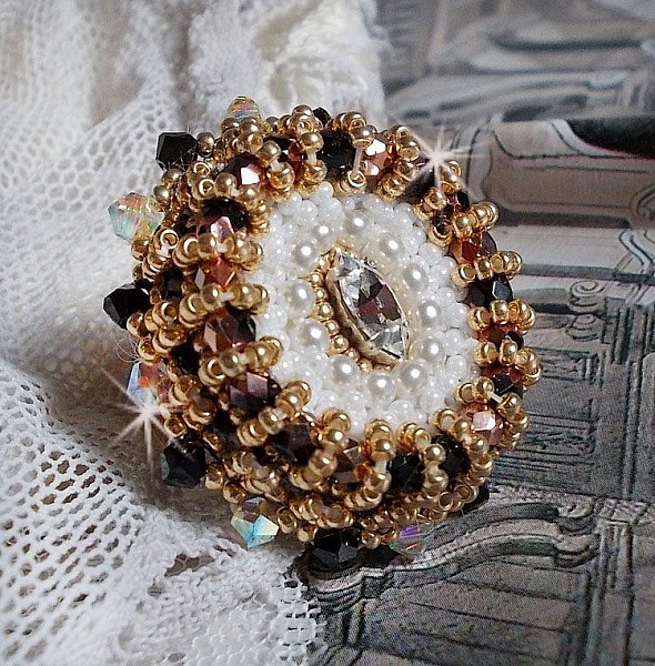 Bague Noir Sacr&eacute; brod&eacute;e avec des cristaux : navette et toupies, perles rondes nacr&eacute;es Blanches &agrave; laquelle s&rsquo;ajoute des facettes en verre de boh&egrave;me Jet Capri Gold et rocailles sur une bague r&eacute;glable
