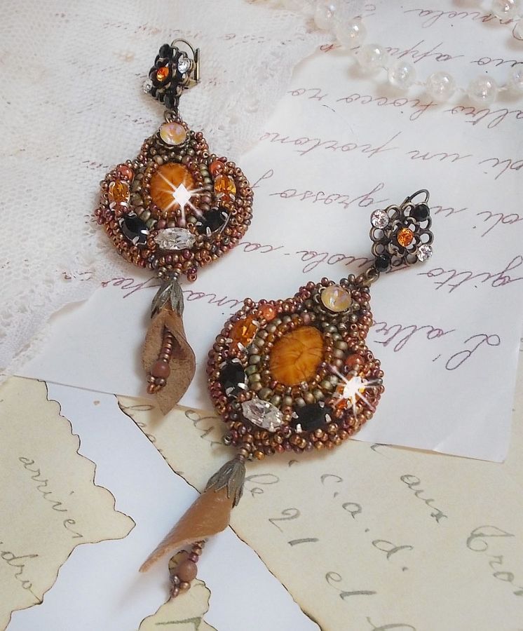 BO Amber Romance avec un cabochon en r&eacute;sine orn&eacute; de cristaux : navettes Topaz, Noir et Cristal avec rocailles. Le cuir compl&egrave;te les pendants avec des perles en Agate sur dormeuses. Un style Am&eacute;rindien