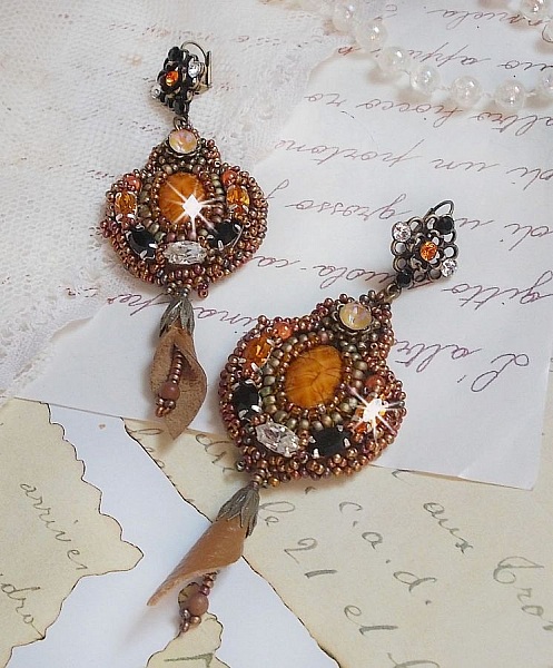 BO Amber Romance avec un cabochon en r&eacute;sine orn&eacute; de cristaux : navettes Topaz, Noir et Cristal avec rocailles. Le cuir compl&egrave;te les pendants avec des perles en Agate sur dormeuses. Un style Am&eacute;rindien