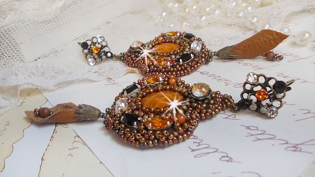 BO Amber Romance avec un cabochon en r&eacute;sine orn&eacute; de cristaux : navettes Topaz, Noir et Cristal avec rocailles. Le cuir compl&egrave;te les pendants avec des perles en Agate sur dormeuses. Un style Am&eacute;rindien