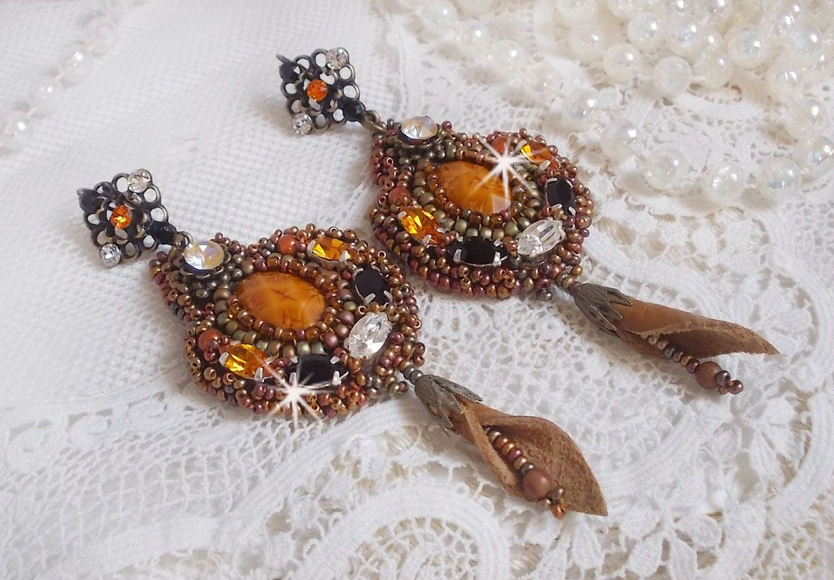 BO Amber Romance avec un cabochon en r&eacute;sine orn&eacute; de cristaux : navettes Topaz, Noir et Cristal avec rocailles. Le cuir compl&egrave;te les pendants avec des perles en Agate sur dormeuses. Un style Am&eacute;rindien