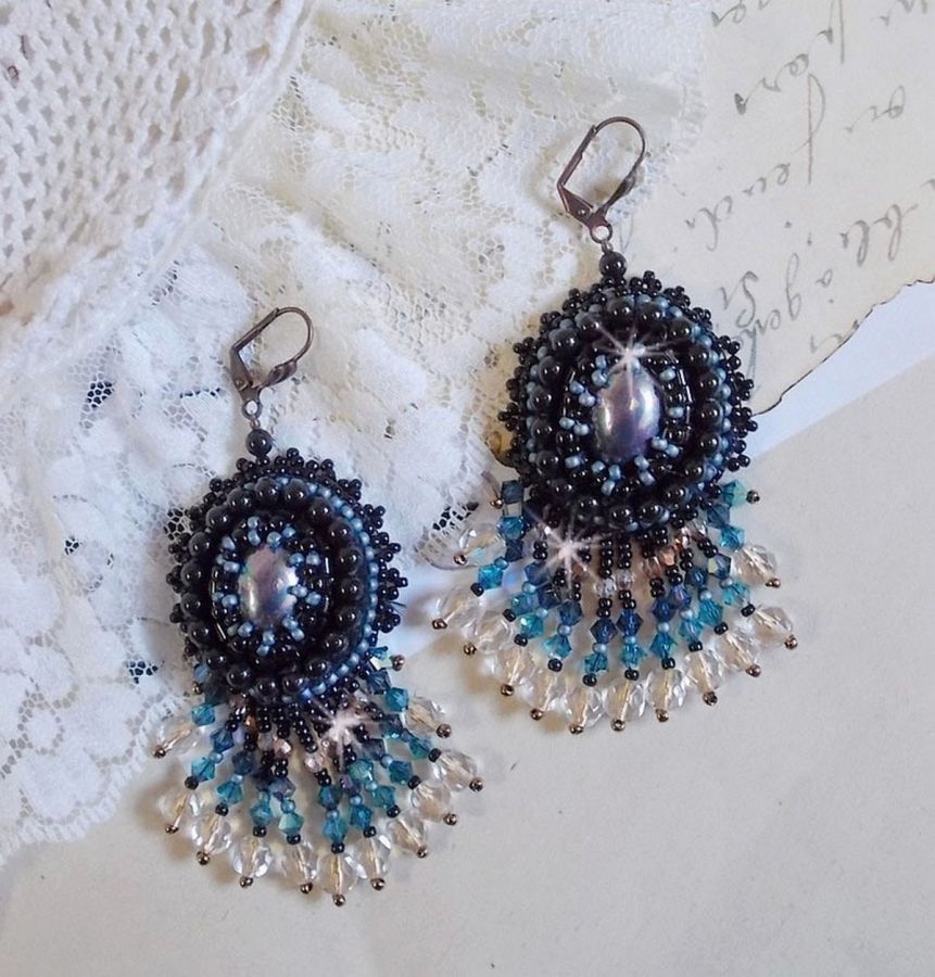 BO Angelot brod&eacute;es avec des cabochons ovales en r&eacute;sine Noire, perles rondes nacr&eacute;es Cristal et toupies. S&rsquo;ajoute des facettes et rocailles. Le tout est mont&eacute; sur des dormeuses Lys en Laiton