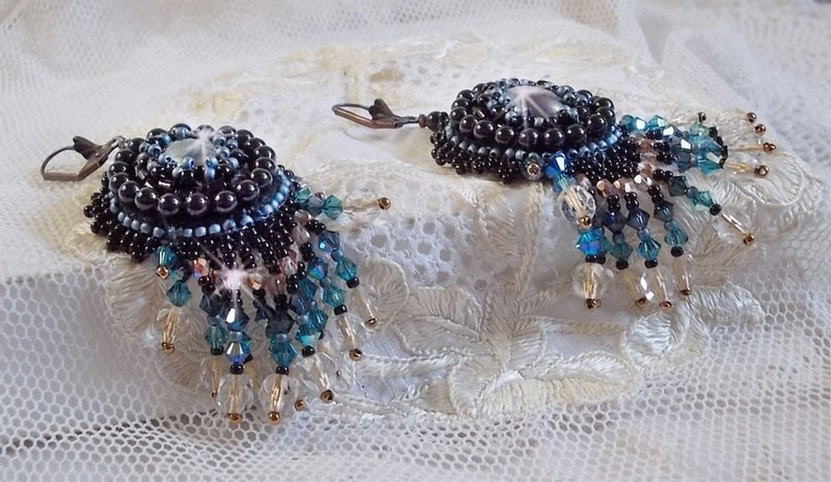 BO Angelot brod&eacute;es avec des cabochons ovales en r&eacute;sine Noire, perles rondes nacr&eacute;es Cristal et toupies. S&rsquo;ajoute des facettes et rocailles. Le tout est mont&eacute; sur des dormeuses Lys en Laiton