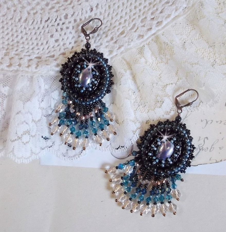 BO Angelot brod&eacute;es avec des cabochons ovales en r&eacute;sine Noire, perles rondes nacr&eacute;es Cristal et toupies. S&rsquo;ajoute des facettes et rocailles. Le tout est mont&eacute; sur des dormeuses Lys en Laiton