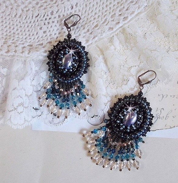 BO Angelot brod&eacute;es avec des cabochons ovales en r&eacute;sine Noire, perles rondes nacr&eacute;es Cristal et toupies. S&rsquo;ajoute des facettes et rocailles. Le tout est mont&eacute; sur des dormeuses Lys en Laiton