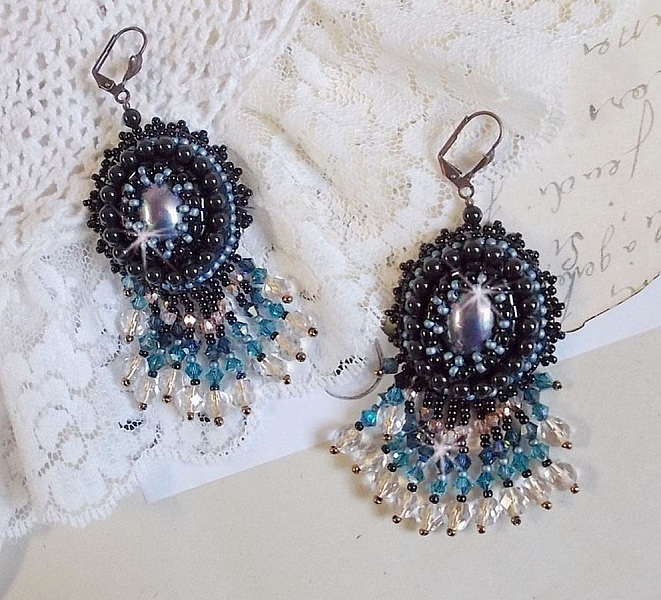 BO Angelot brod&eacute;es avec des cabochons ovales en r&eacute;sine Noire, perles rondes nacr&eacute;es Cristal et toupies. S&rsquo;ajoute des facettes et rocailles. Le tout est mont&eacute; sur des dormeuses Lys en Laiton