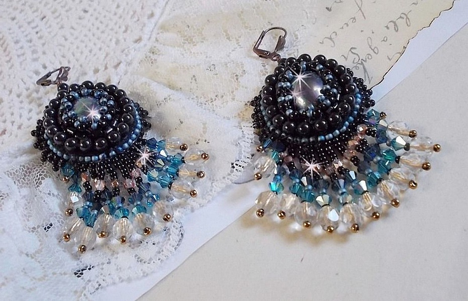 BO Angelot brod&eacute;es avec des cabochons ovales en r&eacute;sine Noire, perles rondes nacr&eacute;es Cristal et toupies. S&rsquo;ajoute des facettes et rocailles. Le tout est mont&eacute; sur des dormeuses Lys en Laiton