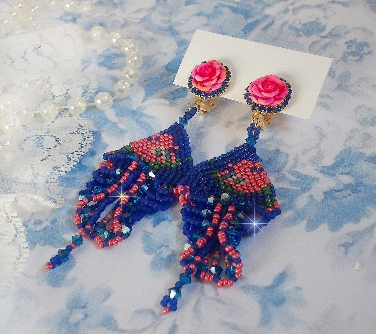BO Bel&rsquo;Nuit Bleue avec cabochons en forme de roses en r&eacute;sine orn&eacute;s d&rsquo;une cha&icirc;ne strass Saphir &agrave; laquelle s&rsquo;ajoute des toupies et rocailles. Le tout est mont&eacute; sur clips Dor&eacute;s Laiton
