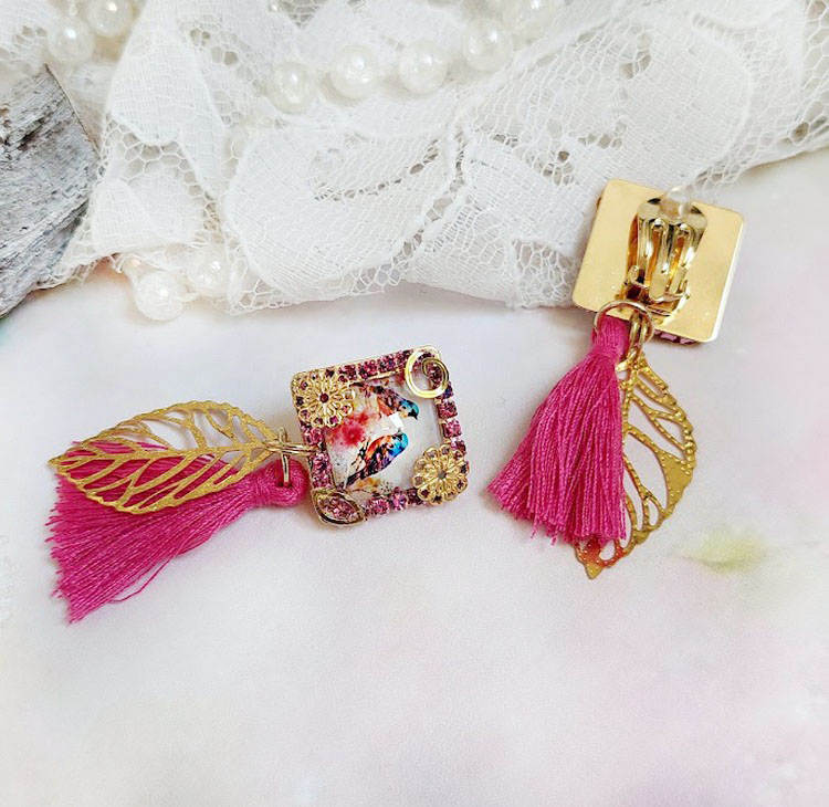 Boucles d'oreilles clips carrées avec pompons roses et breloques.