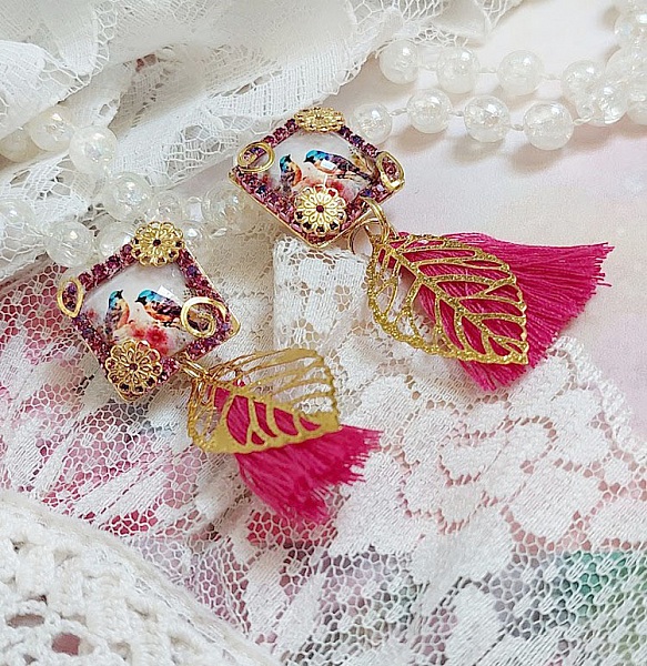 Boucles d'oreilles carrées avec motifs oiseaux, pompons et feuilles dorées.