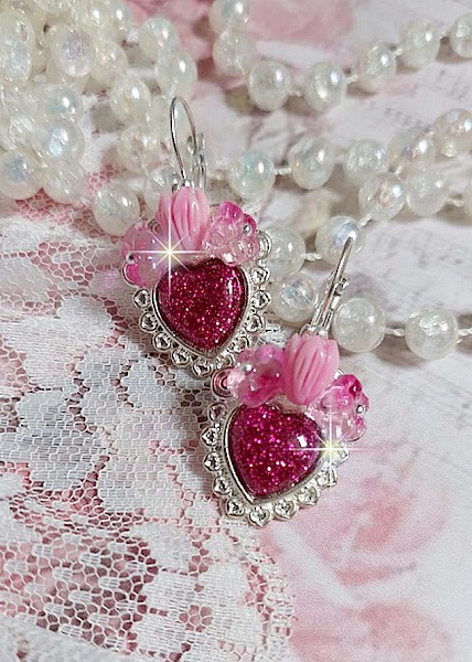 BO C&oelig;ur Ardent mont&eacute;es avec des dormeuses argent&eacute;es &agrave; laquelle s&rsquo;ajoute des c&oelig;urs paillet&eacute;s en r&eacute;sine Fuchsia. Ils sont orn&eacute;s d&rsquo;un bouquet de fleurs en verre &agrave; la couleur Rose pour un style romantique