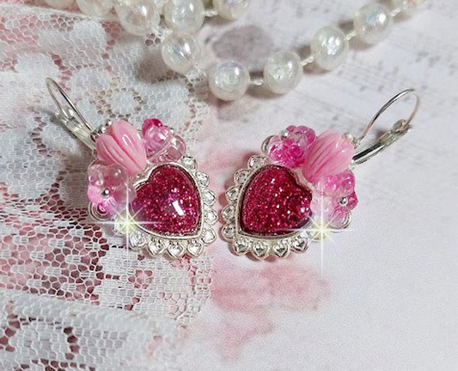 BO C&oelig;ur Ardent mont&eacute;es avec des dormeuses argent&eacute;es &agrave; laquelle s&rsquo;ajoute des c&oelig;urs paillet&eacute;s en r&eacute;sine Fuchsia. Ils sont orn&eacute;s d&rsquo;un bouquet de fleurs en verre &agrave; la couleur Rose pour un style romantique