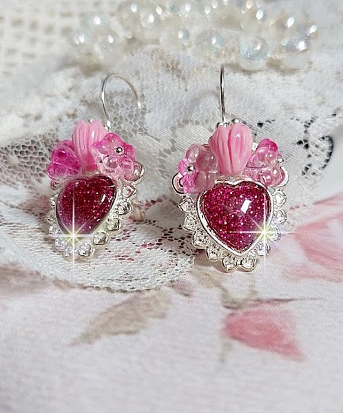 BO C&oelig;ur Ardent mont&eacute;es avec des dormeuses argent&eacute;es &agrave; laquelle s&rsquo;ajoute des c&oelig;urs paillet&eacute;s en r&eacute;sine Fuchsia. Ils sont orn&eacute;s d&rsquo;un bouquet de fleurs en verre &agrave; la couleur Rose pour un style romantique