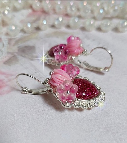 BO C&oelig;ur Ardent mont&eacute;es avec des dormeuses argent&eacute;es &agrave; laquelle s&rsquo;ajoute des c&oelig;urs paillet&eacute;s en r&eacute;sine Fuchsia. Ils sont orn&eacute;s d&rsquo;un bouquet de fleurs en verre &agrave; la couleur Rose pour un style romantique