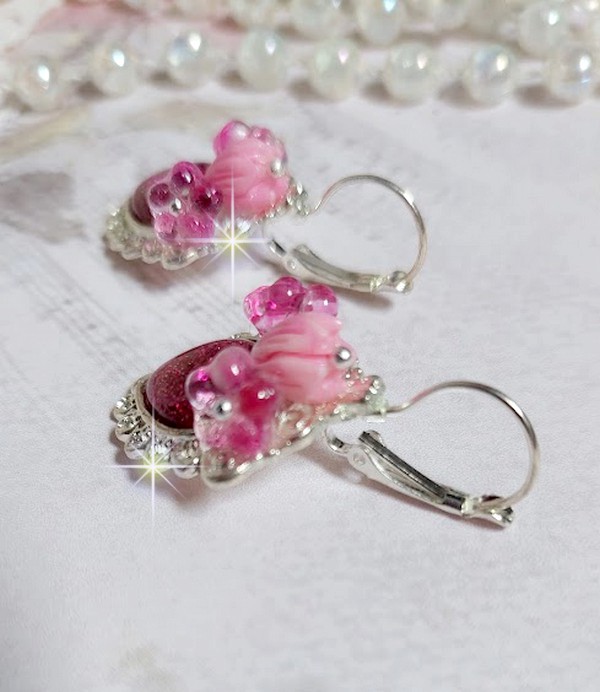 BO C&oelig;ur Ardent mont&eacute;es avec des dormeuses argent&eacute;es &agrave; laquelle s&rsquo;ajoute des c&oelig;urs paillet&eacute;s en r&eacute;sine Fuchsia. Ils sont orn&eacute;s d&rsquo;un bouquet de fleurs en verre &agrave; la couleur Rose pour un style romantique