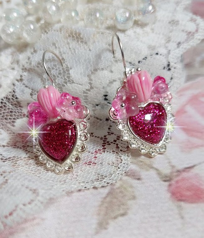 BO C&oelig;ur Ardent mont&eacute;es avec des dormeuses argent&eacute;es &agrave; laquelle s&rsquo;ajoute des c&oelig;urs paillet&eacute;s en r&eacute;sine Fuchsia. Ils sont orn&eacute;s d&rsquo;un bouquet de fleurs en verre &agrave; la couleur Rose pour un style romantique