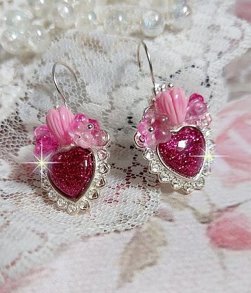 BO C&oelig;ur Ardent mont&eacute;es avec des dormeuses argent&eacute;es &agrave; laquelle s&rsquo;ajoute des c&oelig;urs paillet&eacute;s en r&eacute;sine Fuchsia. Ils sont orn&eacute;s d&rsquo;un bouquet de fleurs en verre &agrave; la couleur Rose pour un style romantique