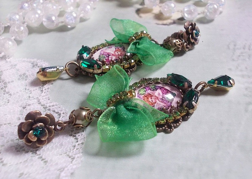 BO C&oelig;ur d&rsquo;Anges avec des cabochons d&rsquo;un petit ange orn&eacute;s d&rsquo;une cha&icirc;ne strass, navettes, poires et cabochons en Cristal. S&rsquo;ajoute des rubans organza sur pendentifs et clous en forme de fleurs.