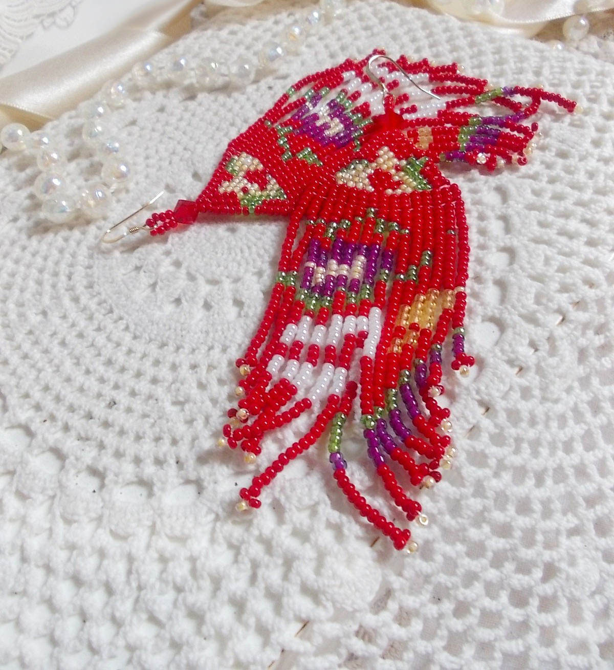 Boucles d'oreilles pendantes artisanales en perles de rocaille rouges.