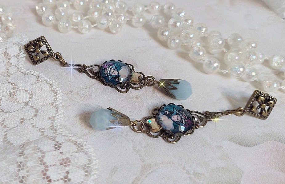 BO Dame au chapeau fleuri repr&eacute;sentant une femme au chapeau entour&eacute; d&rsquo;un ruban noir est mont&eacute; sur des estampes avec des n&oelig;uds en cristal. Une belle &eacute;l&eacute;gance avec ces gouttes en Jade teint&eacute;es de Bleu