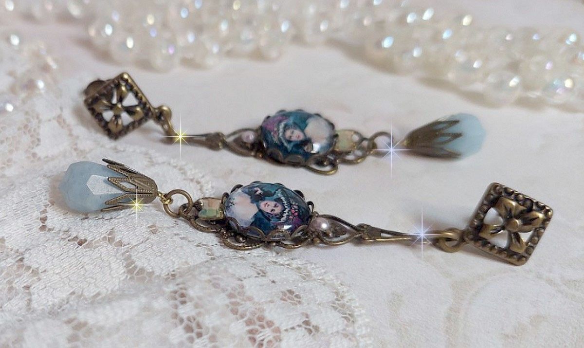 BO Dame au chapeau fleuri repr&eacute;sentant une femme au chapeau entour&eacute; d&rsquo;un ruban noir est mont&eacute; sur des estampes avec des n&oelig;uds en cristal. Une belle &eacute;l&eacute;gance avec ces gouttes en Jade teint&eacute;es de Bleu