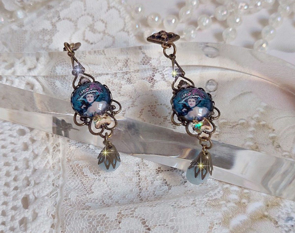 BO Dame au chapeau fleuri repr&eacute;sentant une femme au chapeau entour&eacute; d&rsquo;un ruban noir est mont&eacute; sur des estampes avec des n&oelig;uds en cristal. Une belle &eacute;l&eacute;gance avec ces gouttes en Jade teint&eacute;es de Bleu