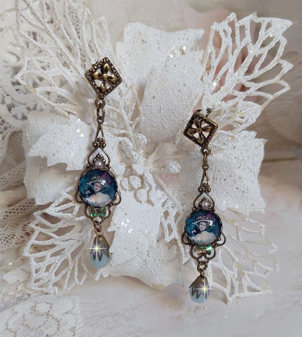 BO Dame au chapeau fleuri repr&eacute;sentant une femme au chapeau entour&eacute; d&rsquo;un ruban noir est mont&eacute; sur des estampes avec des n&oelig;uds en cristal. Une belle &eacute;l&eacute;gance avec ces gouttes en Jade teint&eacute;es de Bleu