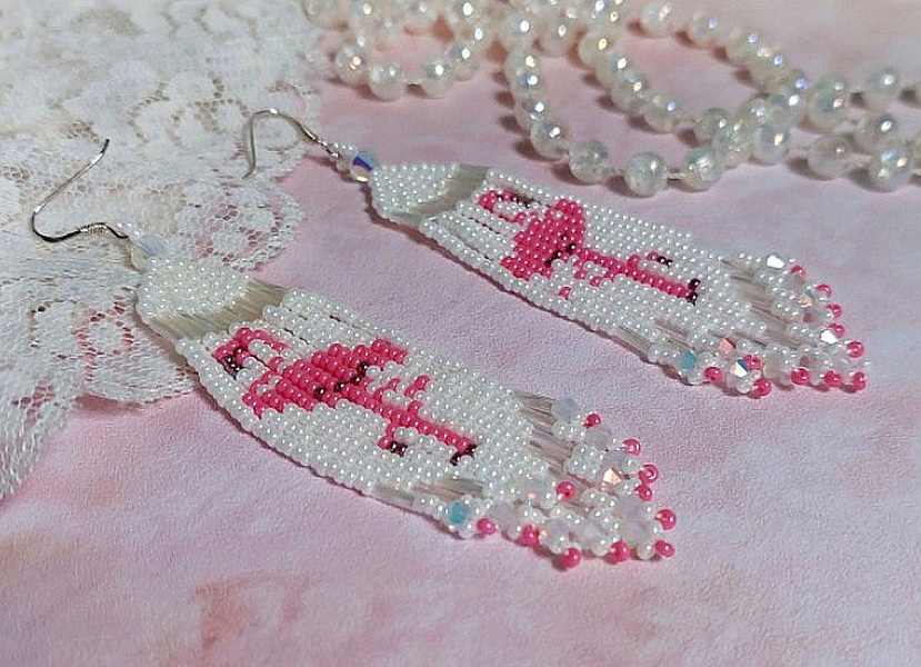 BO Les Flamants Blancs et Roses mont&eacute;es aux rocailles de qualit&eacute; en verre. Couleurs : Blanc et Rose. S&rsquo;ajoute aux rocailles des toupies Blanches. Le tout est associ&eacute; &agrave; des crochets en argent 925.