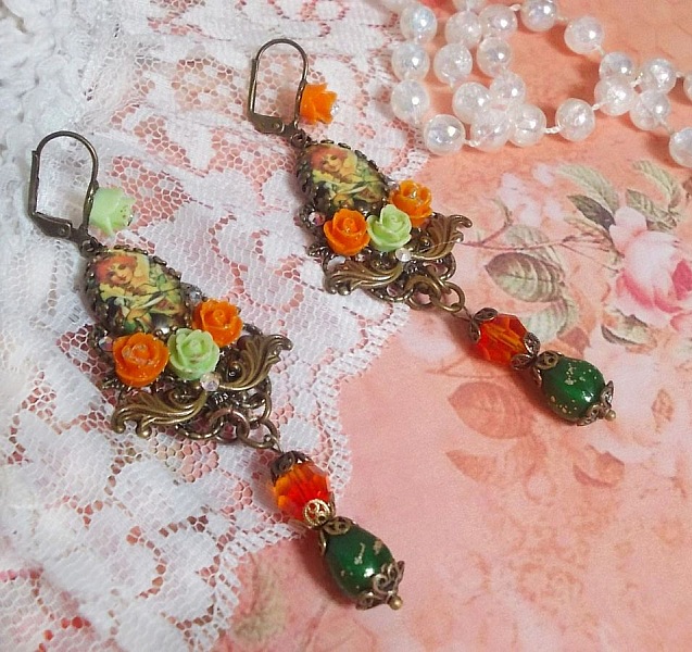 BO F&eacute;es Aloes Potiron repr&eacute;sentant un cabochon d&rsquo;une f&eacute;e aux couleurs roses oranges/Vert Anis, cristaux, estampes et dormeuses Bronze en laiton. Une inspiration d&rsquo;un &ecirc;tre l&eacute;gendaire.