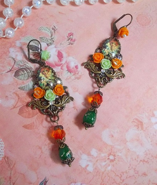 BO F&eacute;es Aloes Potiron repr&eacute;sentant un cabochon d&rsquo;une f&eacute;e aux couleurs roses oranges/Vert Anis, cristaux, estampes et dormeuses Bronze en laiton. Une inspiration d&rsquo;un &ecirc;tre l&eacute;gendaire.