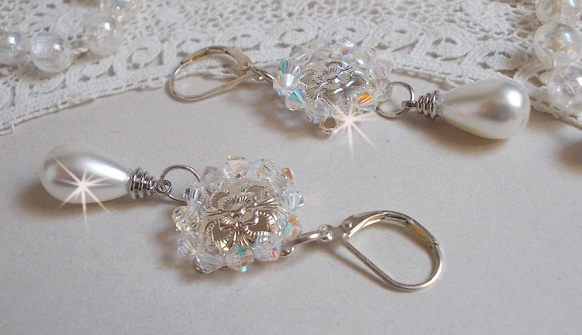 BO Gouttelettes givr&eacute;es aux gouttes Blanches de Majorque avec des estampes &agrave; laquelle s&rsquo;ajoute des toupies en Cristal AB. Le tout est mont&eacute; sur des dormeuses en Argent 925/1000 pour un style moderne