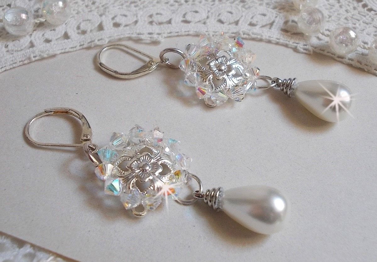 BO Gouttelettes givr&eacute;es aux gouttes Blanches de Majorque avec des estampes &agrave; laquelle s&rsquo;ajoute des toupies en Cristal AB. Le tout est mont&eacute; sur des dormeuses en Argent 925/1000 pour un style moderne