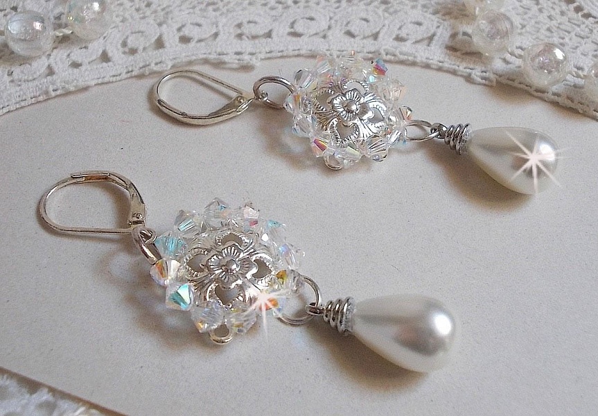 BO Gouttelettes givr&eacute;es aux gouttes Blanches de Majorque avec des estampes &agrave; laquelle s&rsquo;ajoute des toupies en Cristal AB. Le tout est mont&eacute; sur des dormeuses en Argent 925/1000 pour un style moderne