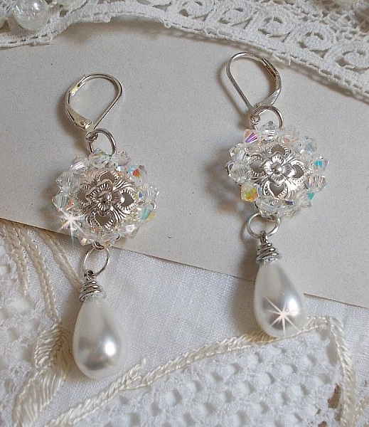 BO Gouttelettes givr&eacute;es aux gouttes Blanches de Majorque avec des estampes &agrave; laquelle s&rsquo;ajoute des toupies en Cristal AB. Le tout est mont&eacute; sur des dormeuses en Argent 925/1000 pour un style moderne