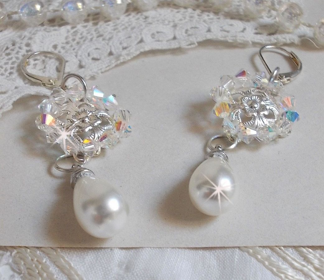 BO Gouttelettes givr&eacute;es aux gouttes Blanches de Majorque avec des estampes &agrave; laquelle s&rsquo;ajoute des toupies en Cristal AB. Le tout est mont&eacute; sur des dormeuses en Argent 925/1000 pour un style moderne