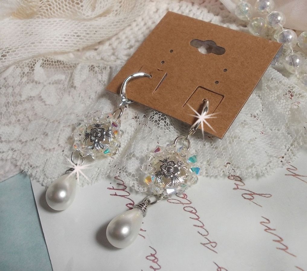 BO Gouttelettes givr&eacute;es aux gouttes Blanches de Majorque avec des estampes &agrave; laquelle s&rsquo;ajoute des toupies en Cristal AB. Le tout est mont&eacute; sur des dormeuses en Argent 925/1000 pour un style moderne
