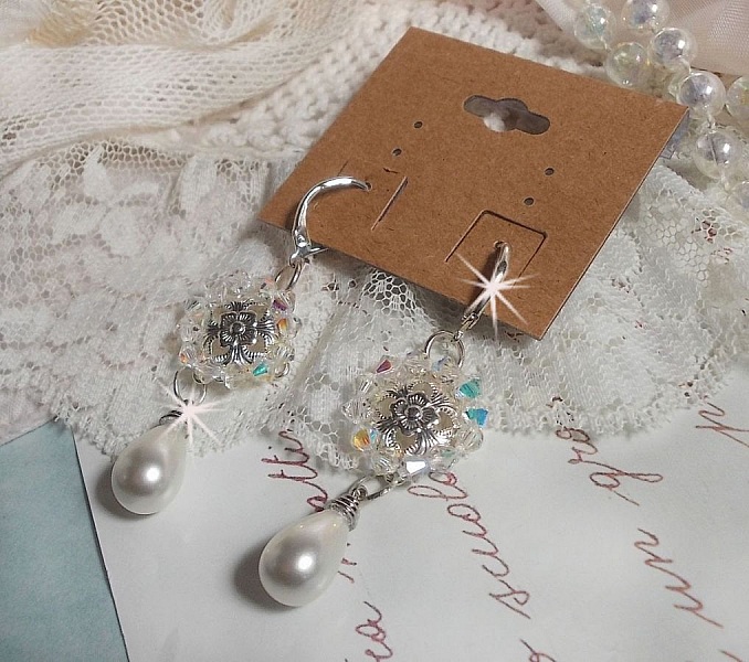 BO Gouttelettes givr&eacute;es aux gouttes Blanches de Majorque avec des estampes &agrave; laquelle s&rsquo;ajoute des toupies en Cristal AB. Le tout est mont&eacute; sur des dormeuses en Argent 925/1000 pour un style moderne