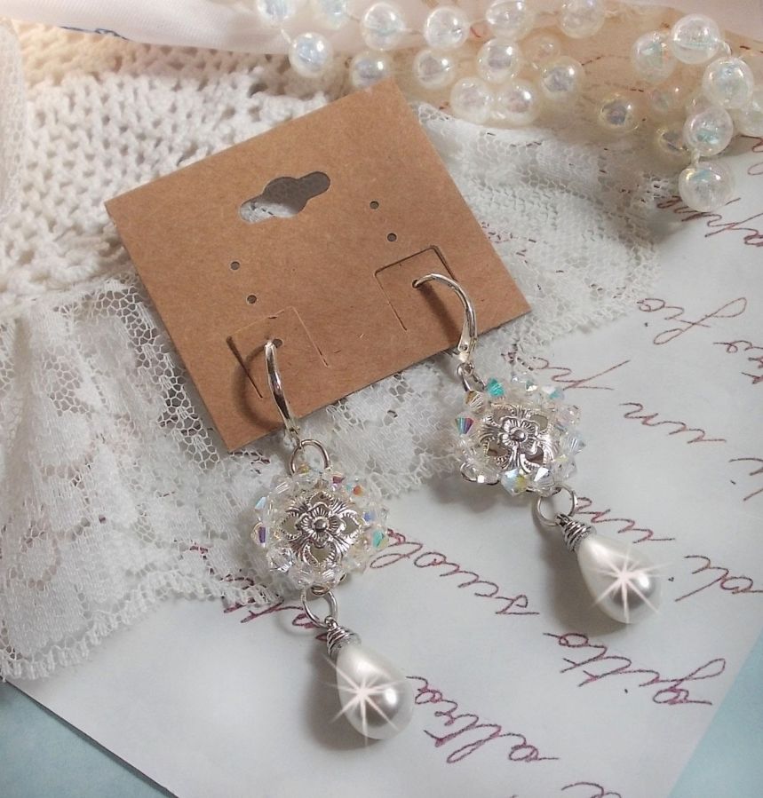 BO Gouttelettes givr&eacute;es aux gouttes Blanches de Majorque avec des estampes &agrave; laquelle s&rsquo;ajoute des toupies en Cristal AB. Le tout est mont&eacute; sur des dormeuses en Argent 925/1000 pour un style moderne