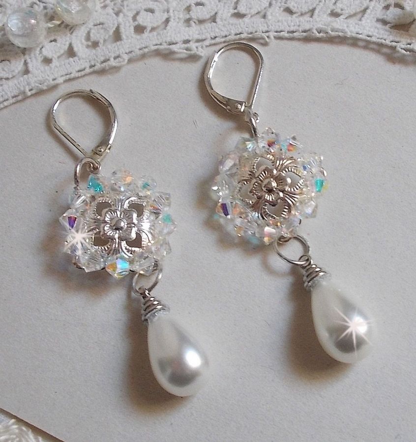 BO Gouttelettes givr&eacute;es aux gouttes Blanches de Majorque avec des estampes &agrave; laquelle s&rsquo;ajoute des toupies en Cristal AB. Le tout est mont&eacute; sur des dormeuses en Argent 925/1000 pour un style moderne