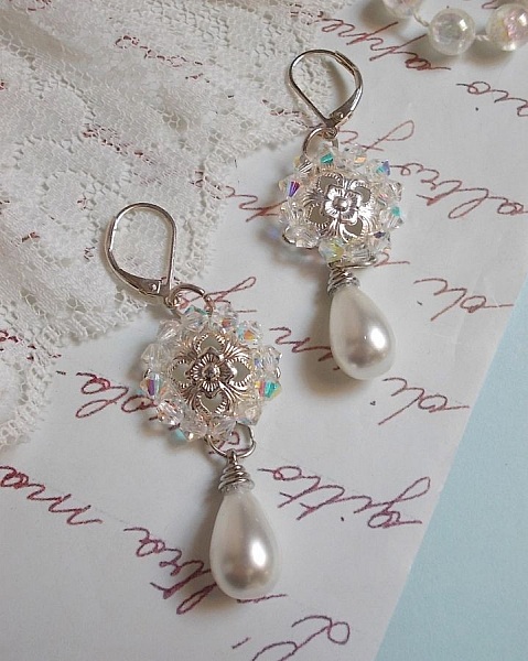 BO Gouttelettes givr&eacute;es aux gouttes Blanches de Majorque avec des estampes &agrave; laquelle s&rsquo;ajoute des toupies en Cristal AB. Le tout est mont&eacute; sur des dormeuses en Argent 925/1000 pour un style moderne