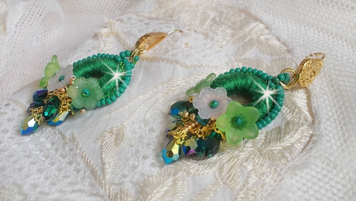 BO Green Iris brod&eacute;es avec du coton DMC Vert sur des anneaux en bois &agrave; laquelle s&rsquo;ajoute des gouttes en cristal, fleurs lucites et rocailles. Mont&eacute;s sur boucles en Laiton. Un style Contemporain !