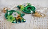 BO Green Iris brod&eacute;es avec du coton DMC Vert sur des anneaux en bois &agrave; laquelle s&rsquo;ajoute des gouttes en cristal, fleurs lucites et rocailles. Mont&eacute;s sur boucles en Laiton. Un style Contemporain !