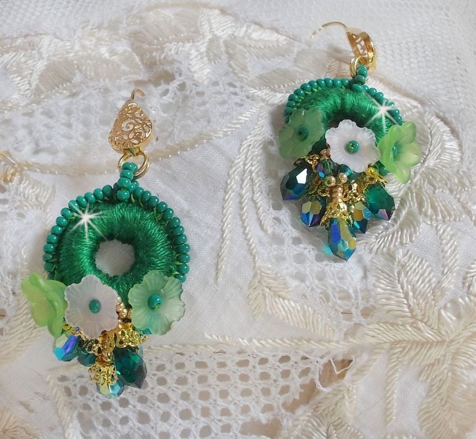 BO Green Iris brod&eacute;es avec du coton DMC Vert sur des anneaux en bois &agrave; laquelle s&rsquo;ajoute des gouttes en cristal, fleurs lucites et rocailles. Mont&eacute;s sur boucles en Laiton. Un style Contemporain !